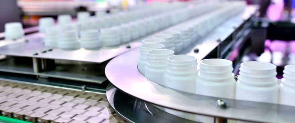 empty pill bottles in an assembly line machine at a factory