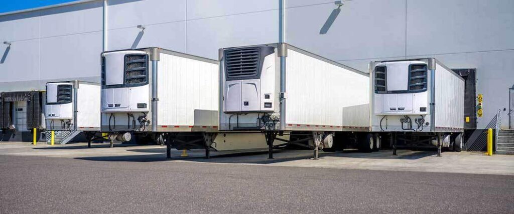 Reefer trailers parked against warehouse docks