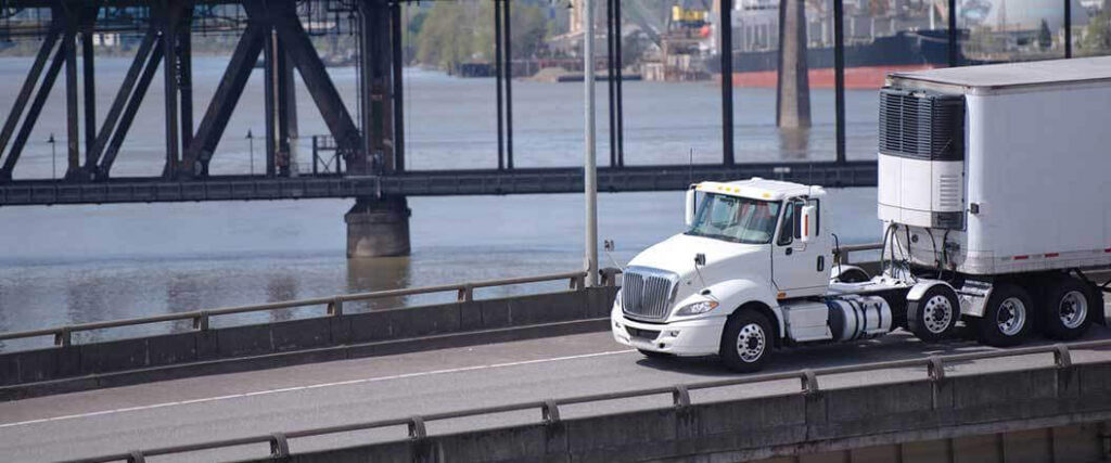 cold chain fulfillment truck driving down a bridge highway