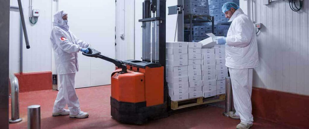 Refrigerated freight workers unloaded a pallet of medicinal products inside a temperature controlled warehouse